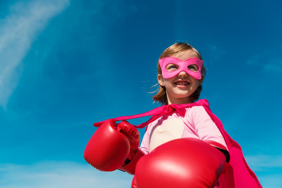 Niña jugando superheroína